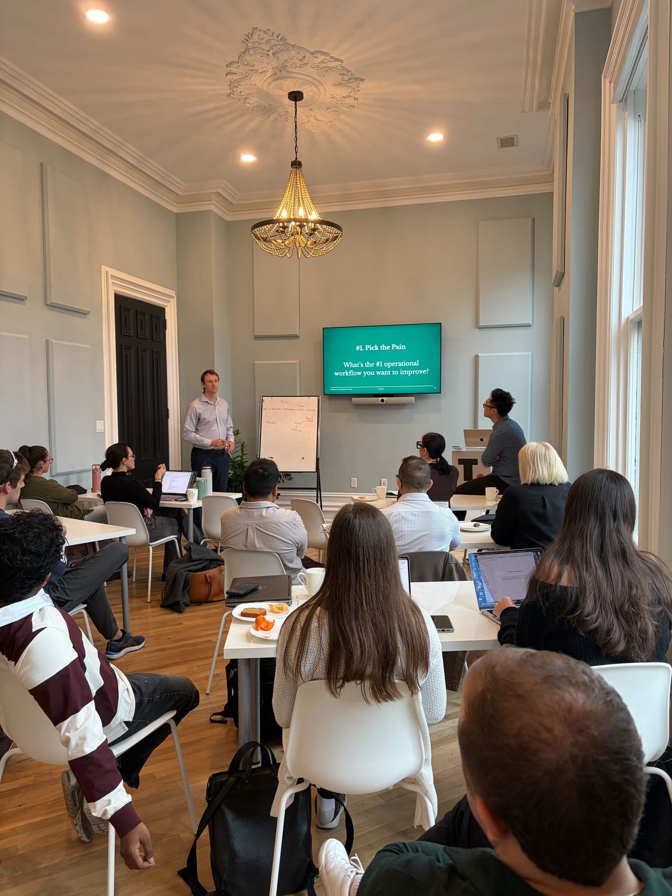 A workshop in progress: Devin Golets at the front of the room asking the group which operational workflow they most want to improve
